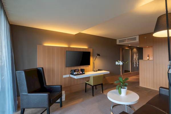 Hotelzimmer im DoubleTree by Hilton Vienna Schonbrunn mit Schreibtisch, Fernseher und Couch
