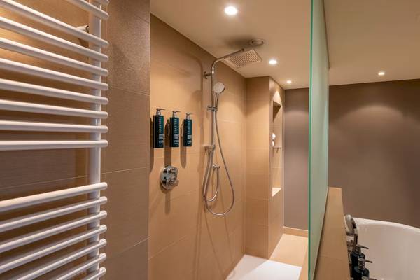 Badezimmer im DoubleTree by Hilton Vienna Schonbrunn mit Dusche und Badewanne.