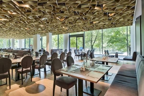 Innenansicht des Restaurants im DoubleTree by Hilton Vienna Schonbrunn mit geometrischen Deckenverkleidungen und großen Fenstern.