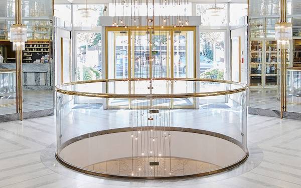 Empfangsbereich des Living Hotel Kaiser Franz Joseph mit Glas und Goldakzenten.