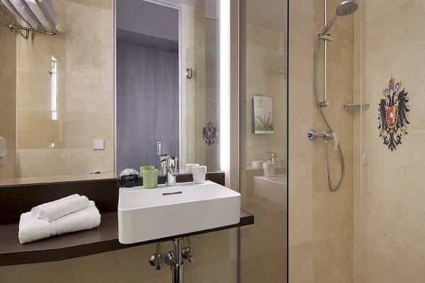 Badezimmer des Living Hotel Kaiser Franz Joseph mit Waschbecken und Dusche.