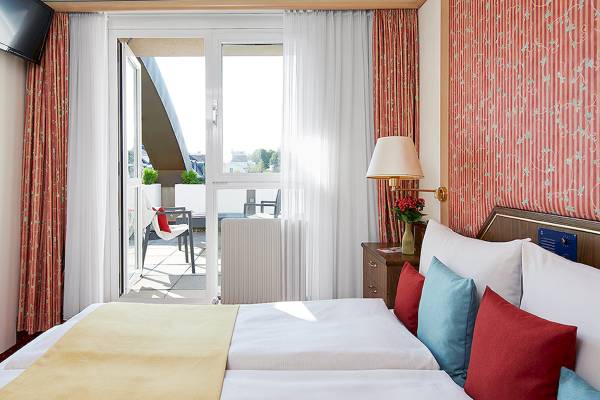 Hotelzimmer des Living Hotel Kaiser Franz Joseph mit Balkon und zwei Betten.