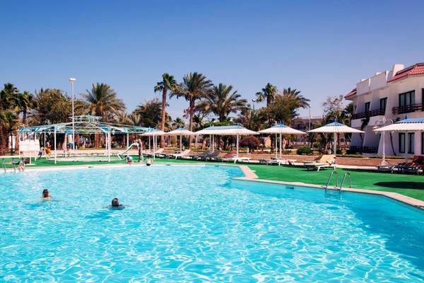 Außenpool des Grand Hotel Hurghada mit schwimmenden Gästen und Sonnenschirmen.