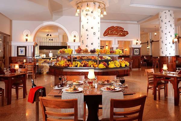 Innenansicht des Restaurants im Pickalbatros Palace Resort, Hurghada, mit gedeckten Tischen und Früchten.