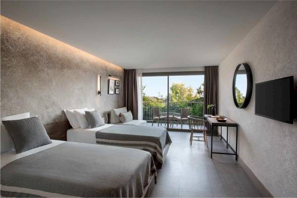 Doppelzimmer im Club Marvy Hotel mit zwei Betten und Balkon.