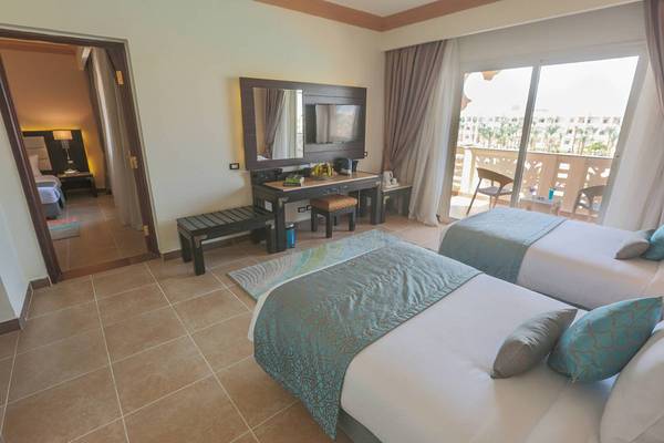 Doppelzimmer im Pickalbatros Palace Resort, Hurghada mit zwei Betten, Schreibtisch und Balkon.