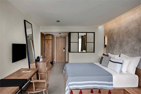 Ein modernes Hotelschlafzimmer im Club Marvy mit einem großen Bett, einem Schreibtisch und einem Flachbildfernseher.