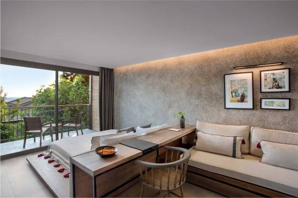 Innenansicht einer Suite im Club Marvy Hotel mit großem Bett, Schreibtisch und Balkon.