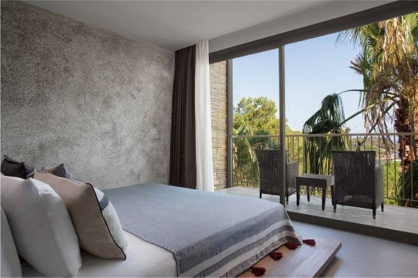 Schlafzimmer im Club Marvy Hotel mit Blick auf einen Balkon und Palmen