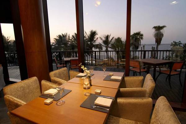 JA Beach Hotel Terrasse mit Tisch und Blick auf das Meer.