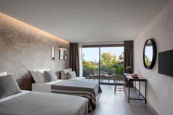 Doppelzimmer im Club Marvy mit zwei Betten, Blick auf den Balkon und Außenbereich.