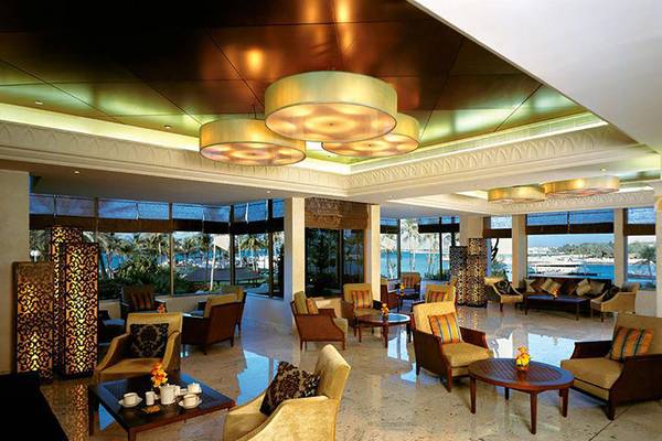 Lobby des JA Beach Hotel mit Blick auf das Meer und modernen Möbeln.