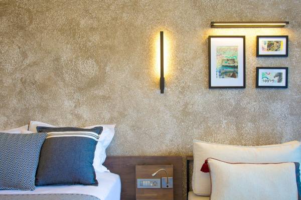 Schlafzimmer im Club Marvy Hotel mit zwei Betten, Nachttischen und Dekorahmen an der Wand.
