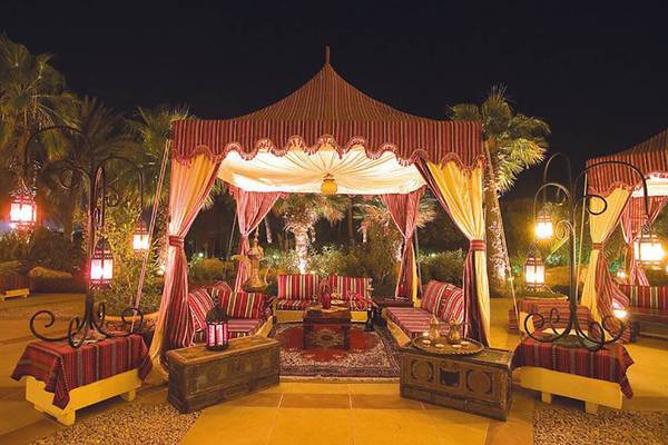 Arabische Lounge im JA Beach Hotel bei Nacht mit roten und gelben Vorhängen und Lampen.