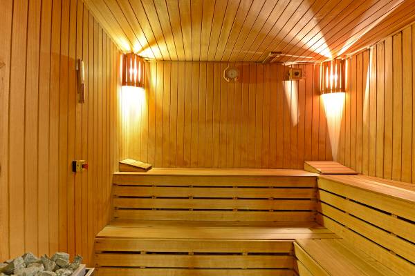 Innenansicht eines Saunaraums im Yigitalp Hotel mit Holzwänden und Bänken, beleuchtet.