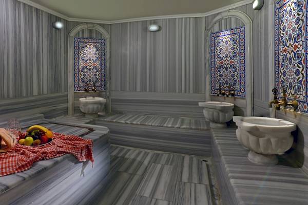 Innenansicht der Sauna im Yigitalp Hotel mit Marmorwänden, dekorativen Fliesen und Früchten auf dem Tisch.