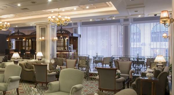 Empfangshalle des Yigitalp Hotels mit vielen Stühlen, Tischen und einer Couch.