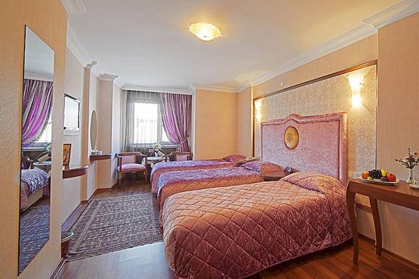 Schlafzimmer im Antea Palace Hotel & Spa mit drei Betten, Nachttischen und Dekor.