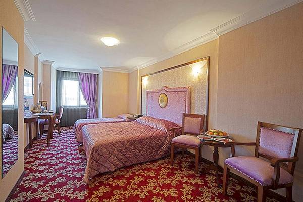 Doppelzimmer im Antea Palace Hotel & Spa mit zwei Betten, Tisch, Stühlen und Obstplatte.