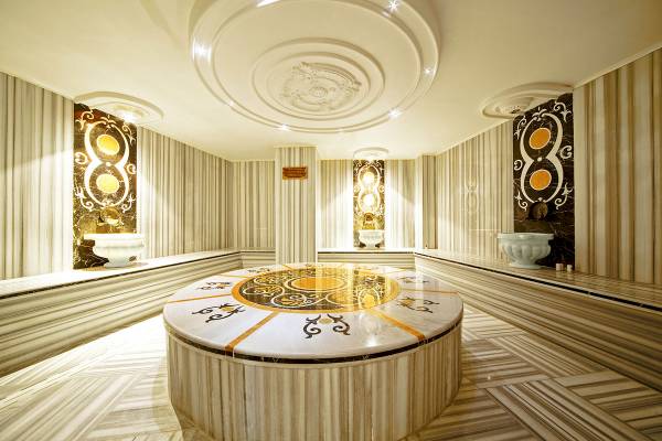 Sauna Bereich im Antea Palace Hotel & Spa mit zentralen Tisch, dekorativen Wandverkleidungen und Sitzbänken.
