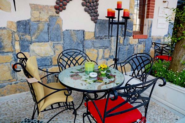 Terrasse des Antea Palace Hotel & Spa mit Tisch und Stühlen, umgeben von Steinmauer und Pflanzen