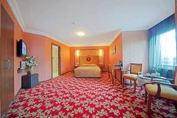 Schlafzimmer im Antea Palace Hotel & Spa mit rotem Teppich, einem Doppelbett und einem Fernseher