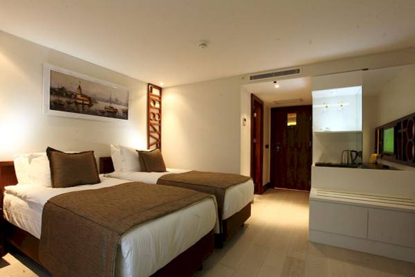 Doppelzimmer im Victory Hotel & Spa Istanbul mit zwei Betten, Dekor und einem Bild an der Wand.