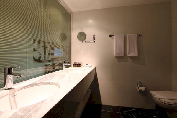 Badezimmer im Victory Hotel & Spa Istanbul mit zwei Waschbecken, Spiegel und Toilette.