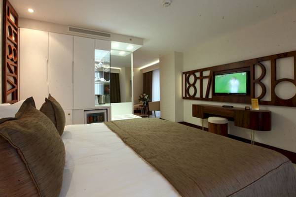 Schlafzimmer im Victory Hotel & Spa Istanbul mit Fernseher, Bett und Möbeln.
