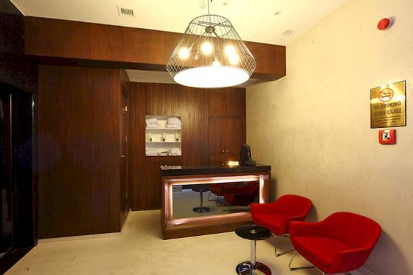 Lobby des Victory Hotel & Spa Istanbul mit roten Sesseln und Schreibtisch.