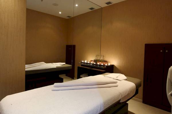 Spa-Behandlungsraum im Victory Hotel & Spa Istanbul mit zwei Behandlungsbetten und einem Tisch mit Kerzen.