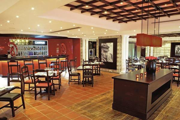 Innenansicht des JA Beach Hotel Restaurants mit Bar, Tischen, Stühlen und Dekoration.