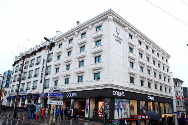 Das Victory Hotel & Spa Istanbul steht an einer regennassen Straße mit Colins Laden darunter.