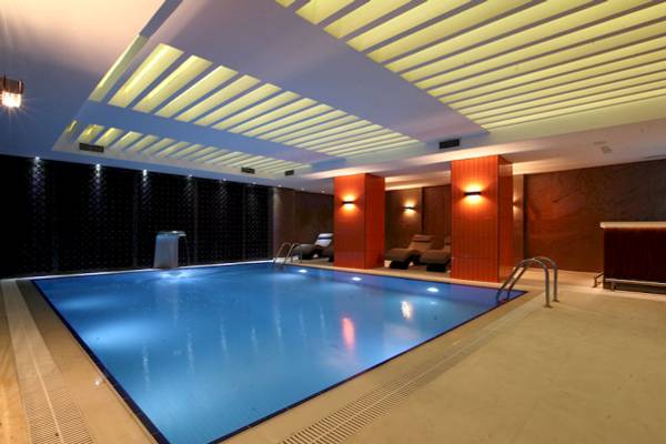 Innenpool des Victory Hotel & Spa Istanbul mit Liegestühlen und Beleuchtung