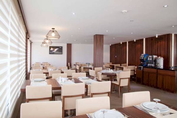 Innenansicht des Restaurants im Victory Hotel & Spa Istanbul mit gedeckten Tischen und Stühlen.