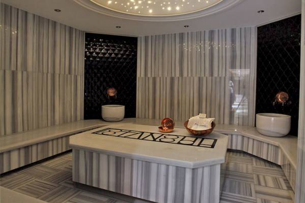 Innenbereich des Victory Hotel & Spa Istanbul mit Marmorwänden und Sitzbänken.
