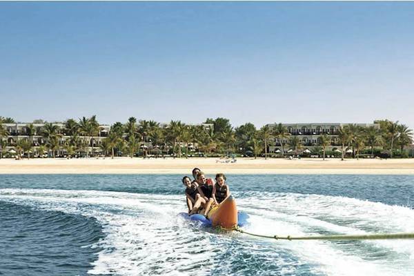 Vier Personen auf einer Banana Boot Fahrt vor dem JA Beach Hotel