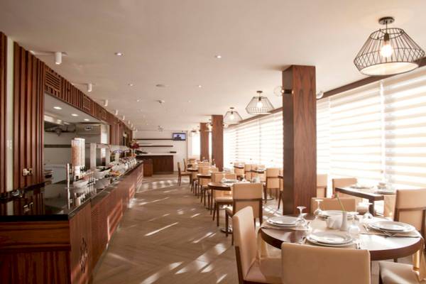 Innenraum des Victory Hotel & Spa Istanbul mit geometrischen Mustern, hölzernen Möbeln und Tischdecken.