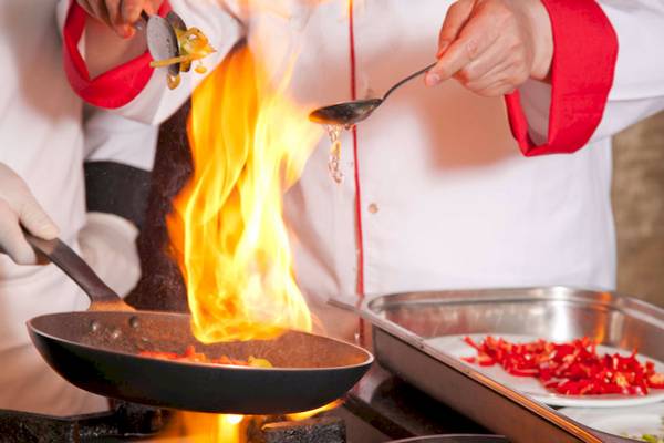 Koche mit Feuer im Topf und roten Pfeffer auf einem Teller im Victory Hotel & Spa Istanbul