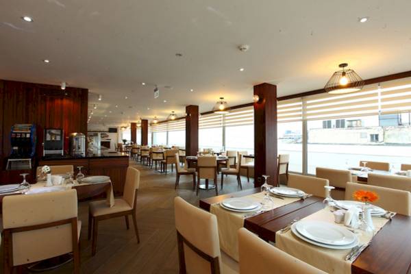 Innenansicht des Restaurants im Victory Hotel & Spa Istanbul mit gedeckten Tischen und Stühlen.