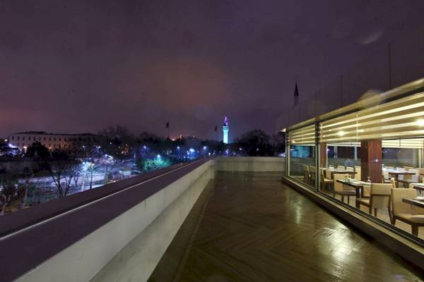 Dachterrasse des Victory Hotel & Spa Istanbul bei Nacht mit Blick auf die Stadt.