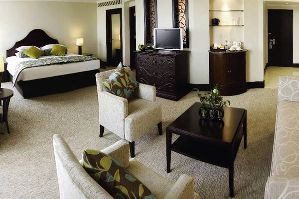 Suite-Zimmer im JA Beach Hotel mit Doppelbett, Wohnzimmer und Nachttisch