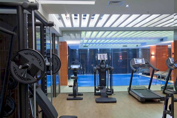 Fitnessstudio im Victory Hotel & Spa Istanbul mit Swimmingpool, Laufband und anderen Geräten.