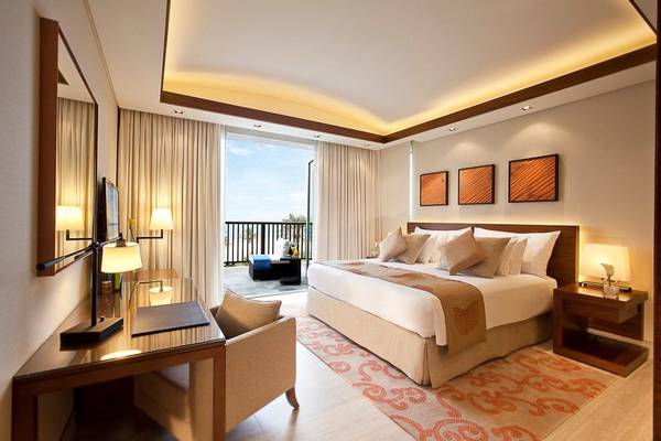 JA Beach Hotel Suite Zimmer mit Meerblick, Bett, Schreibtisch und Möbeln.