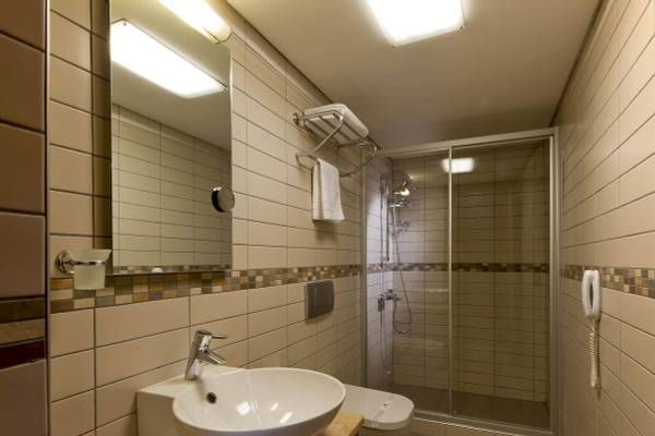 Badezimmer im Golden City Hotel Istanbul mit einer Dusche, Toilette und Waschbecken.