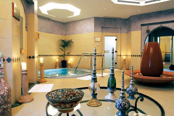 Innenbereich des JA Beach Hotels mit einem kleinen Pool, dekorativen Gegenständen und Pflanzen.