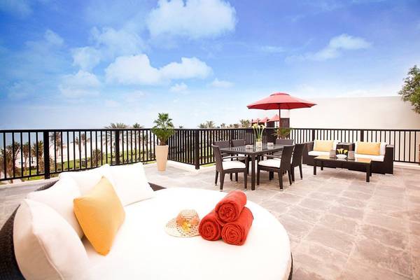Balkon im JA Beach Hotel mit Blick auf den Strand und eine Terrassenlandschaft.