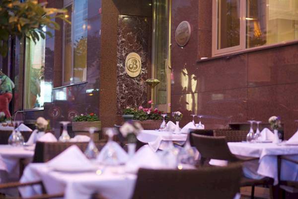 Terrasse des Barin Hotels mit gedeckten Tischen und Blumenarrangements.