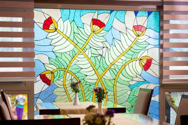 Gemustertes Fenster im Barin Hotel zeigt bunte Blumen.