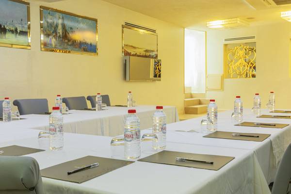 Konferenzraum im Ipek Palas Hotel mit gedeckten Tischen und Wasserflaschen.